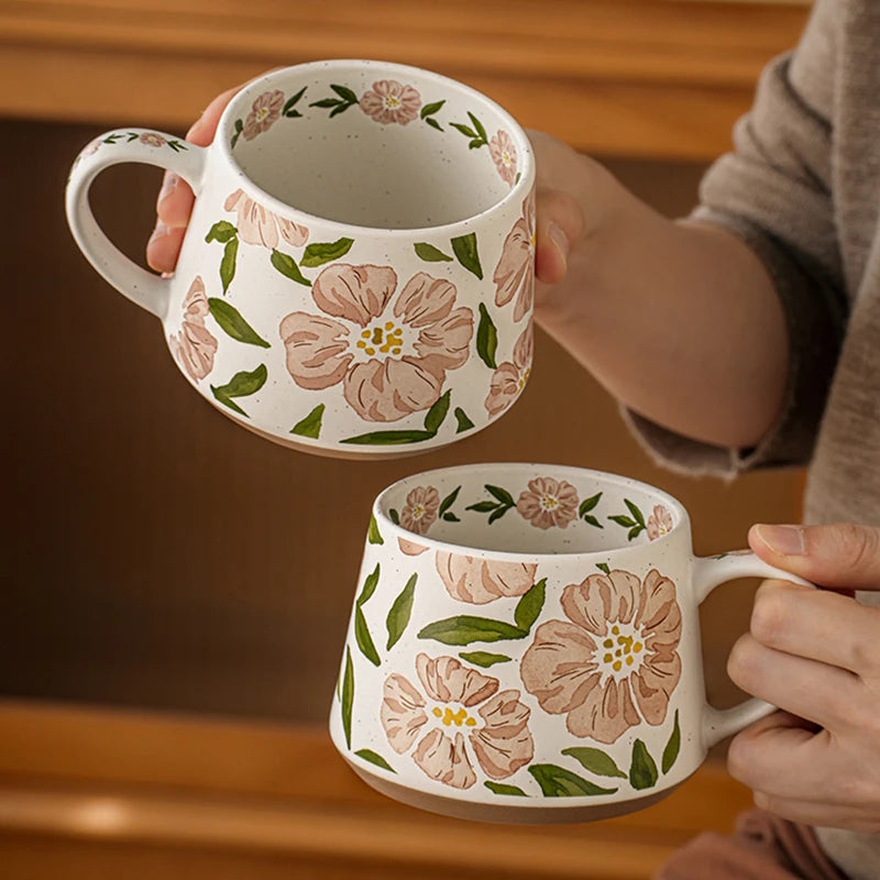Holding Two Camellia Flower Mugs With Enchanting Botanicals Floral Design Inside Cup